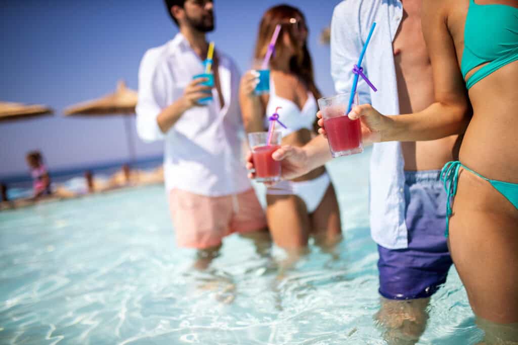 7 Resort Etiquette Mistakes Everyone Makes (and How to Avoid Them) 3 Group of friends having fun on summer vacation and drinking coctails