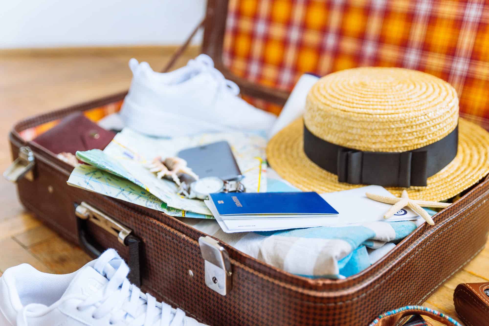 Master Packing for Paradise With These 15 Tips 10 Woman's staff in a vsuitcase with travel documents