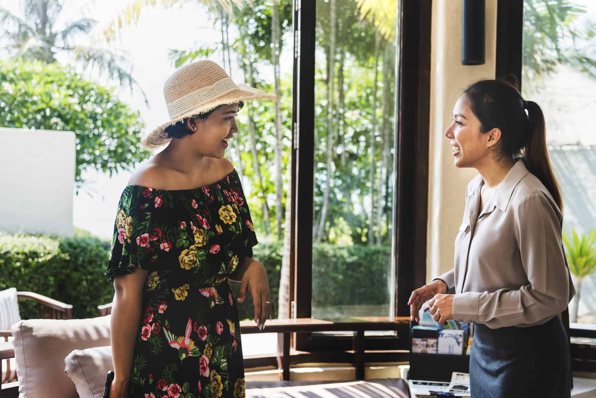 Young asian woman talking to personnel at hotel