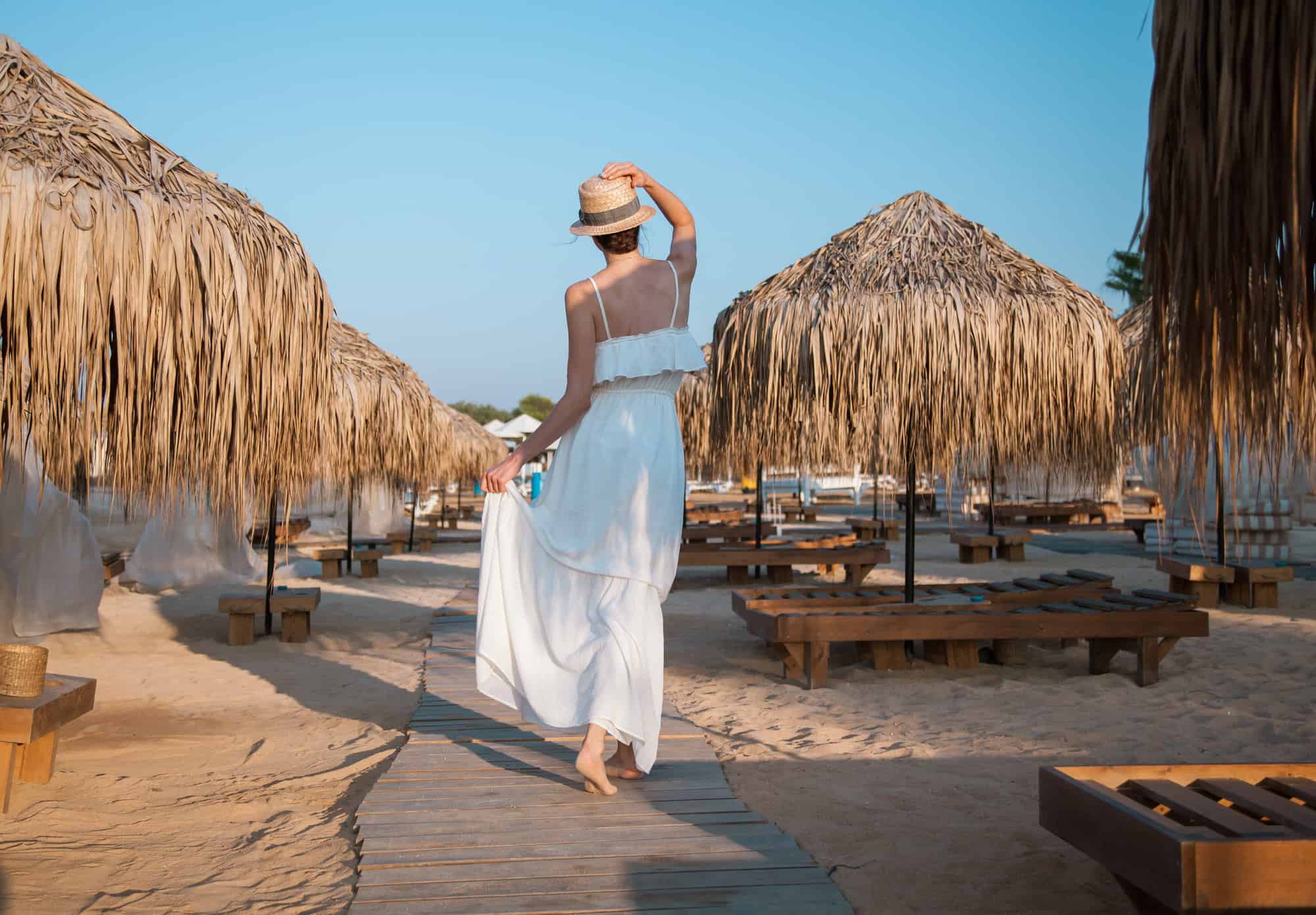 7 Resort Etiquette Mistakes Everyone Makes (and How to Avoid Them) 2 Young woman walking by the beach