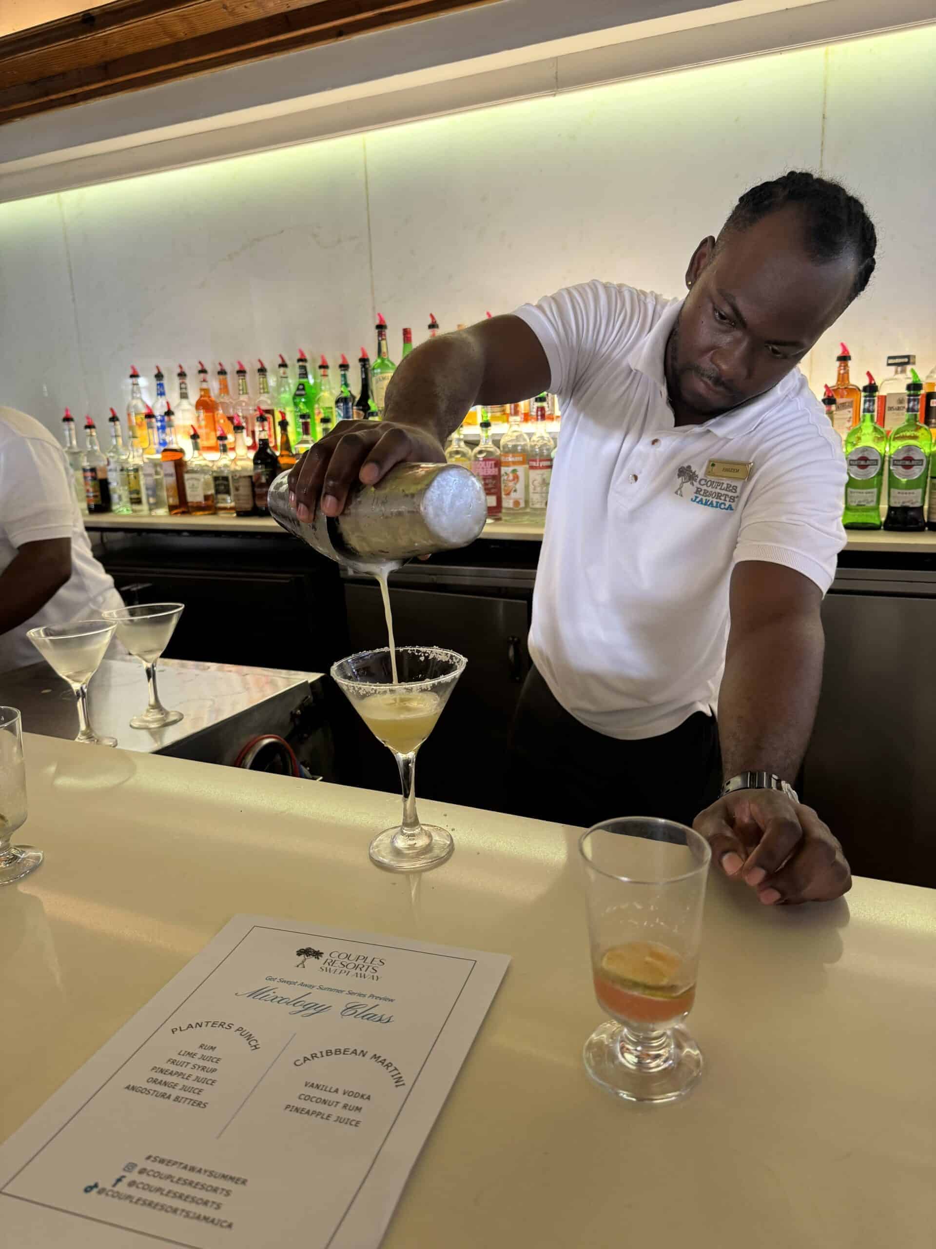 bartender pours a cocktail into a glass