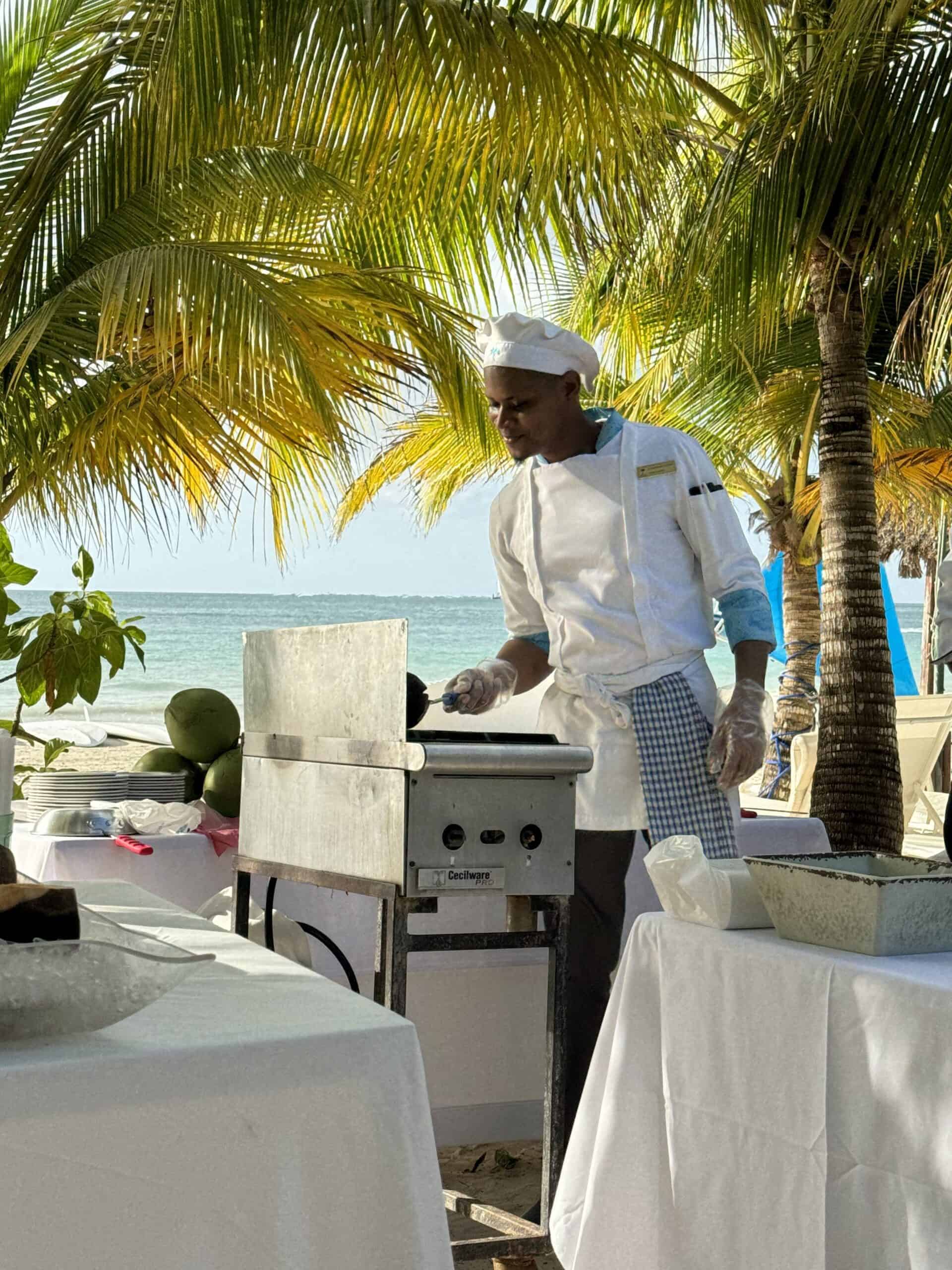 young chef cooking on the grill on the beach