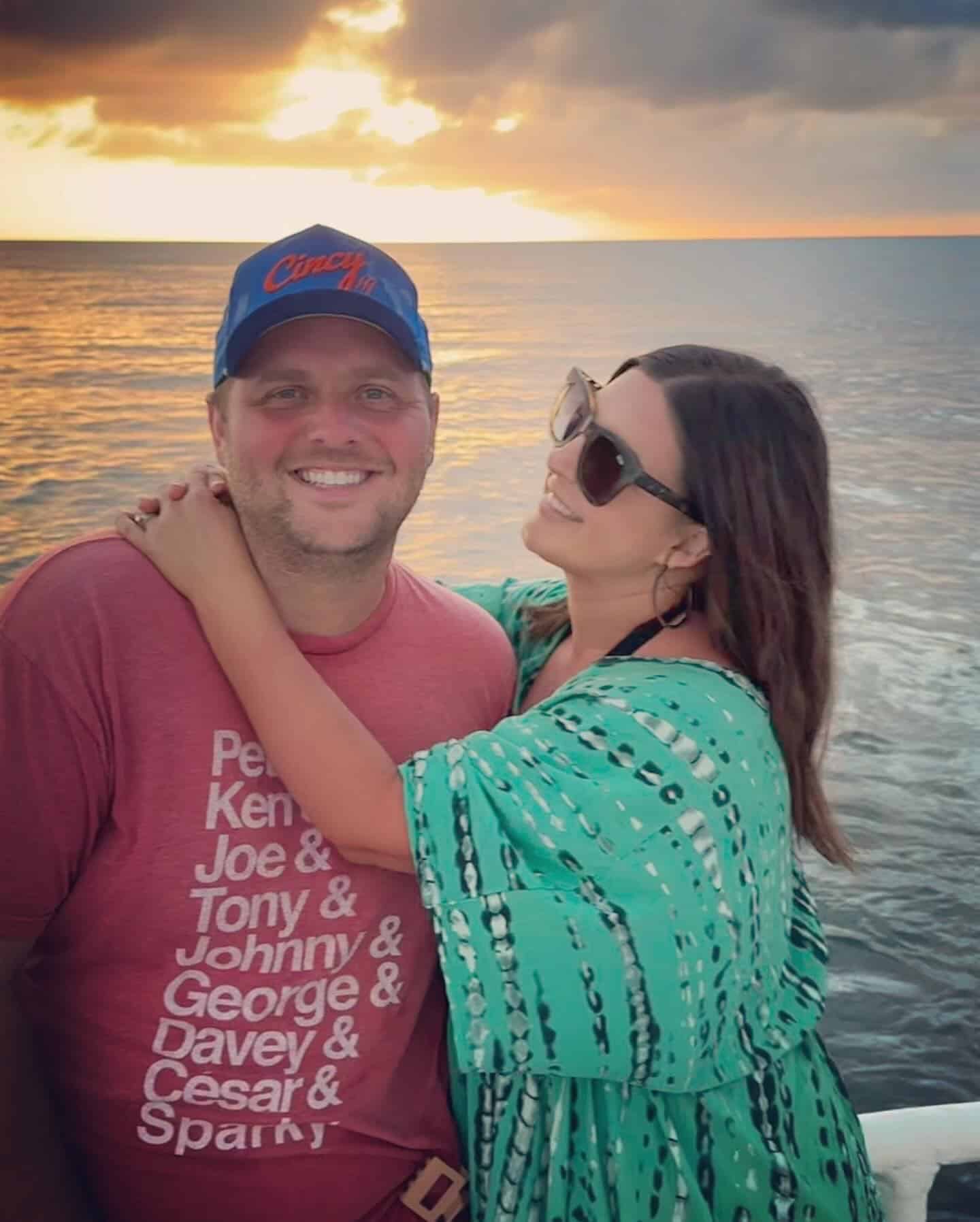 young couple hugging against the backdrop of the ocean and sunset