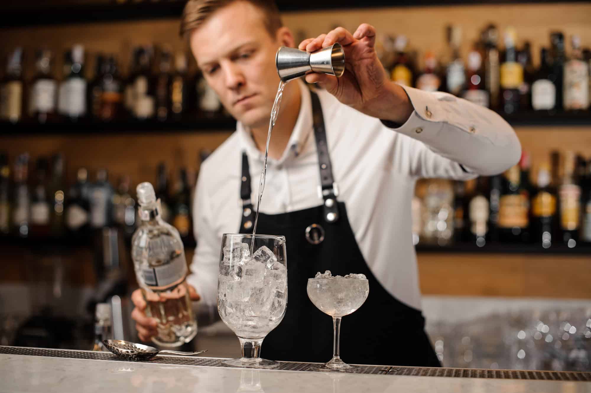 12 Things That Totally Annoy Poolside Bartenders – And What to Do Instead 4 Barman pouring a portion of vodka into a glass