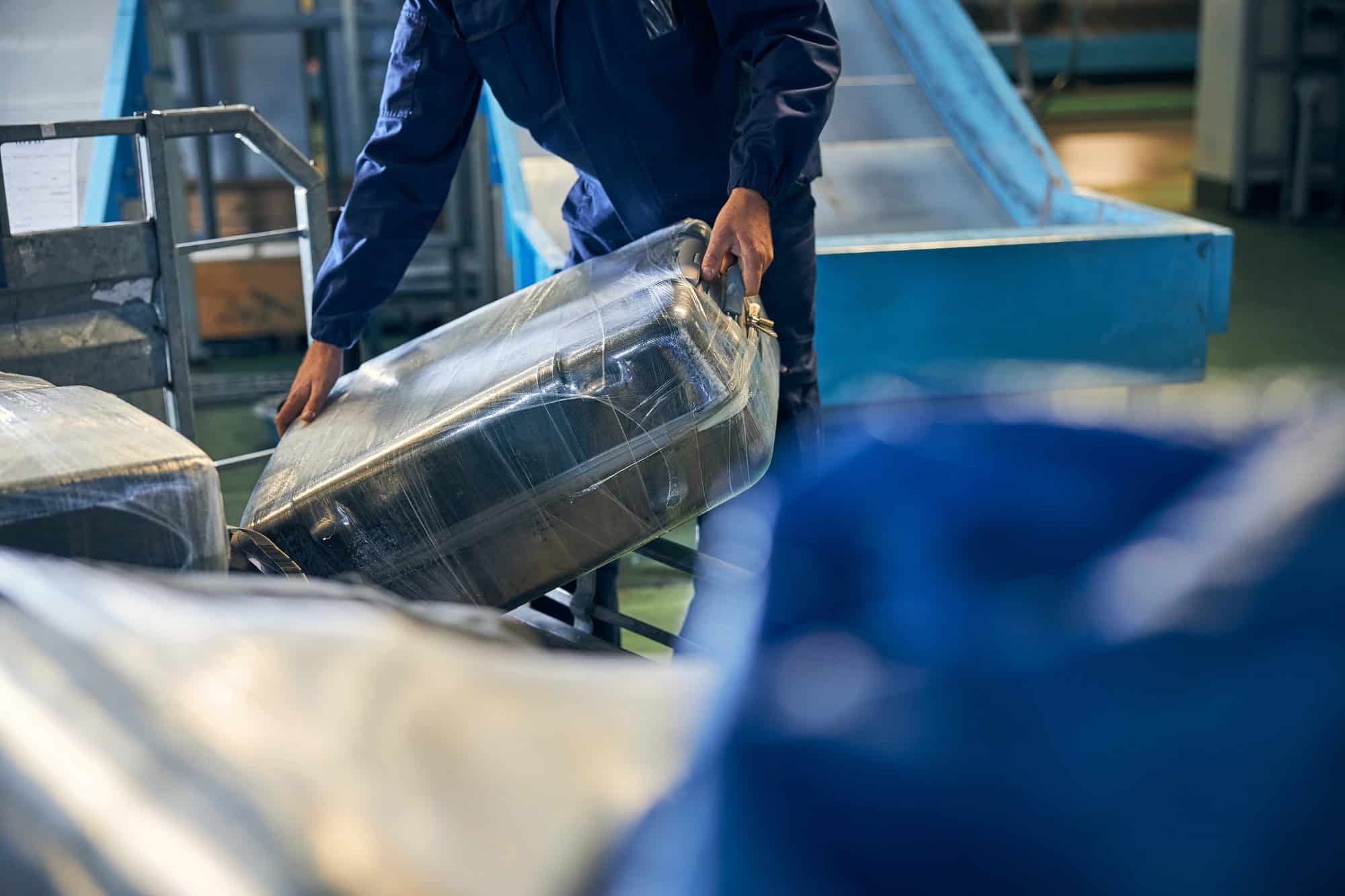 The Genius Trick to Keep Your Luggage From Getting Lost at the Resort 3 Luggage handler holding a suitcase